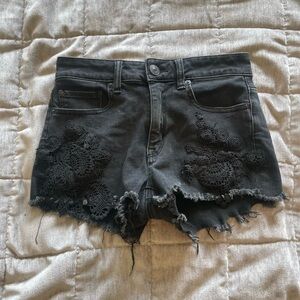 Black lace trimmed distressed jean shorts